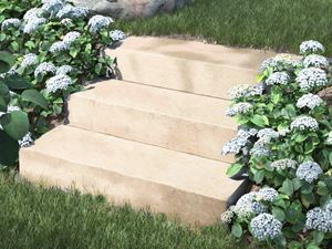 Blockstufen Kalkstein Camino Sand mit Blumen und Gebsch