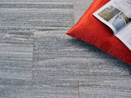 Gneisplatten Urban Grey Line mit orangefarbenem Kissen und Zeitschrift
