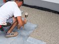 Mann verlegt Blausteinplatten im Edelsplittbett