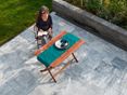 Mit Stil entspannen auf einer Afyon Grey Terrasse! (Kundenprojekt) Frau sitzt an Holztisch auf einer Terrasse mit Platten aus Marmor