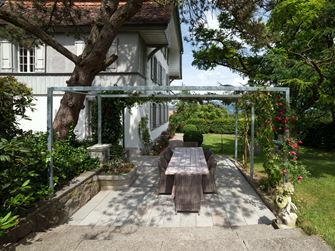 Terrasse mit Natursteinplatten aus grauem Sandstein in natürlichem Garten