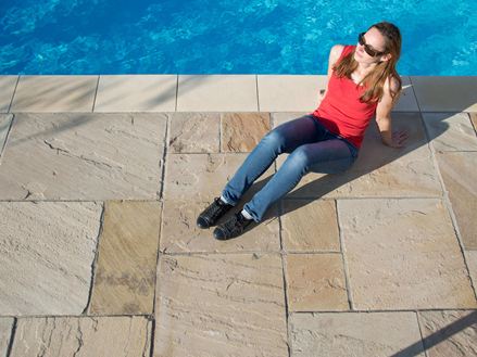 Abendsonne auf den Sandsteinplatten Yellow Mint mit Frau am Pool
