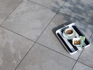 Tablett mit Kaffee auf Feinsteinzeugplatten in hellgrauer Schieferoptik Alpine Grey von oben fotografiert