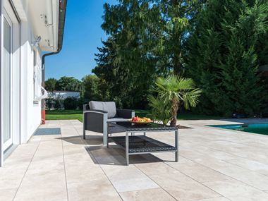 Rattan-Möbel auf schicker Travertin-Terrasse
