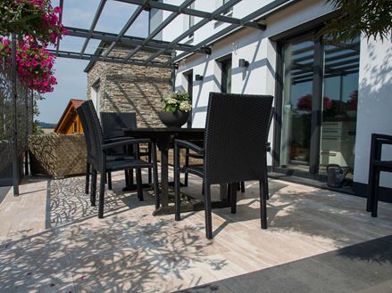 Terrasse mit schwarzen Möbeln und Travertin Natura in Holzoptik