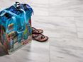 Marmor-Fliesen Calacatta mit bunter Strandtasche und Sandalen