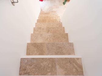 Treppe mit weissen Wänden und Travertin Medium als Trittplatten