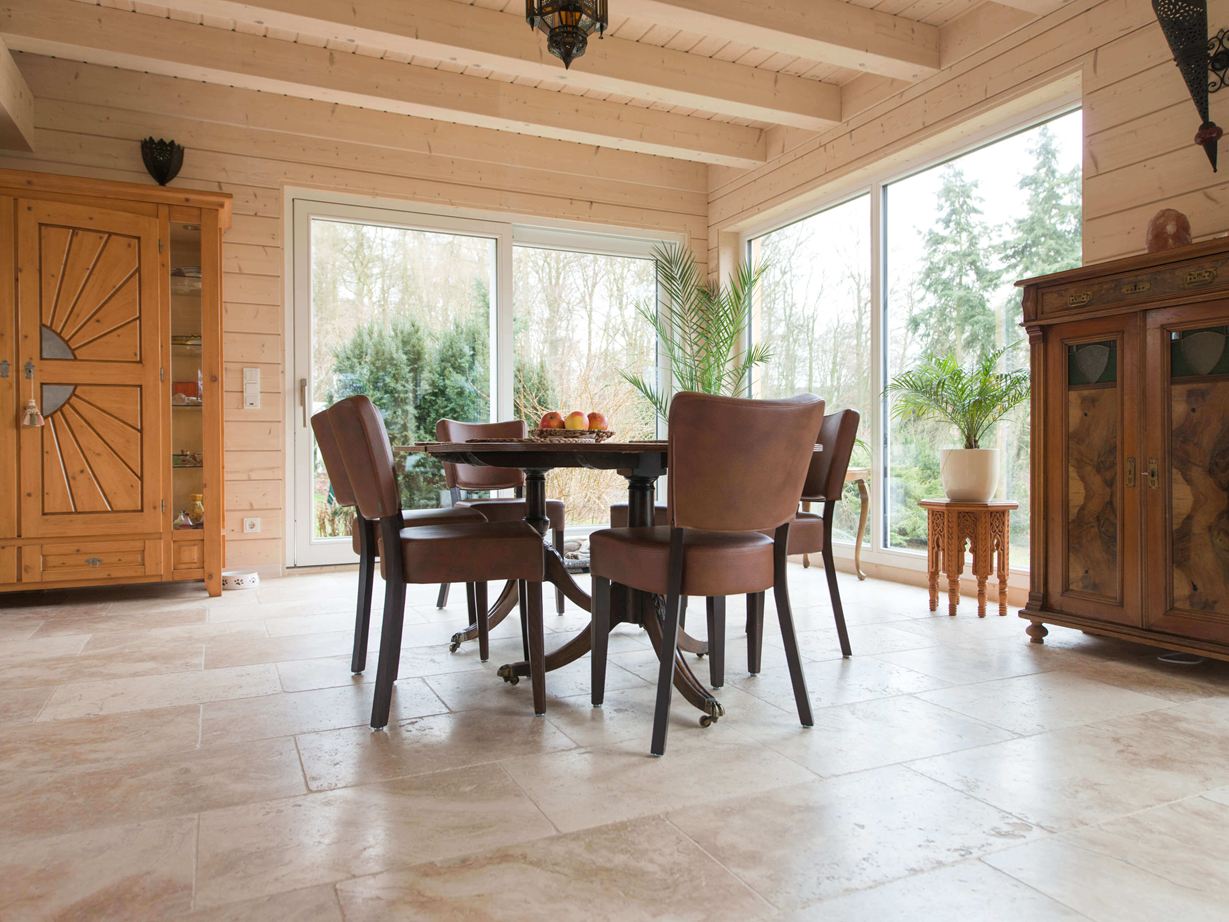 Essbereich mit Holzmöbeln und Travertin Rustic als Bodenbelag