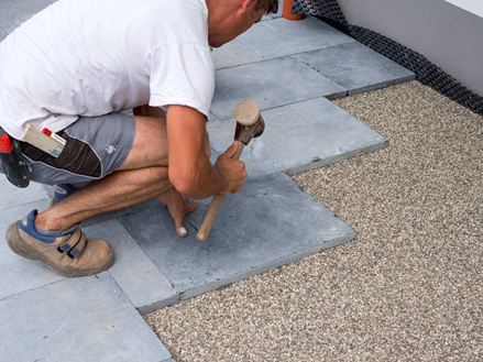 Terrassenplatten aus Blaustein werden in einem Edelsplittbett verlegt