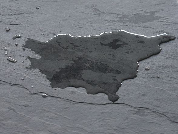 Dunkle Schieferfliese mit Wasserlache