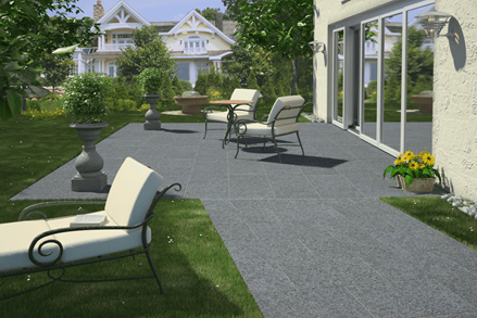 Terrasse mit Basaltplatten und modernen Möbeln, links ein grüner Garten
