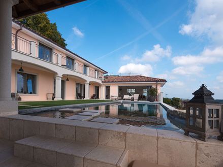 Blick auf Pool und Haus mit Travertinplatte Light in sanftem Beige